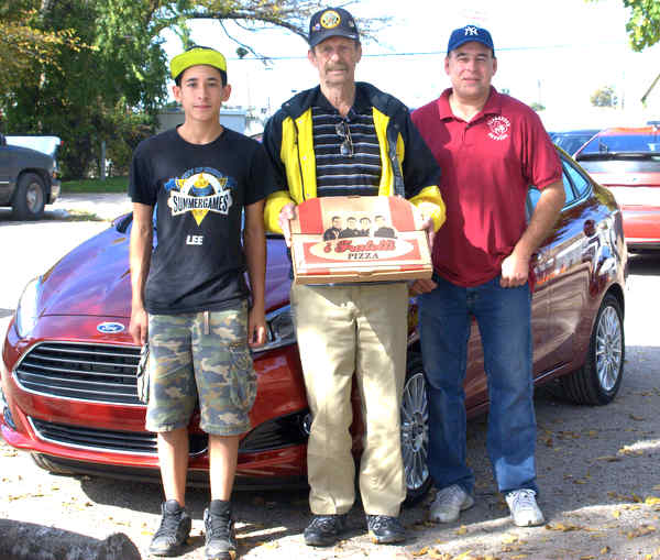 The son of PizzaSpotz founder (left), American Legion post commander Charlie Peoples (center) and PizzaSpotz Founder (right)